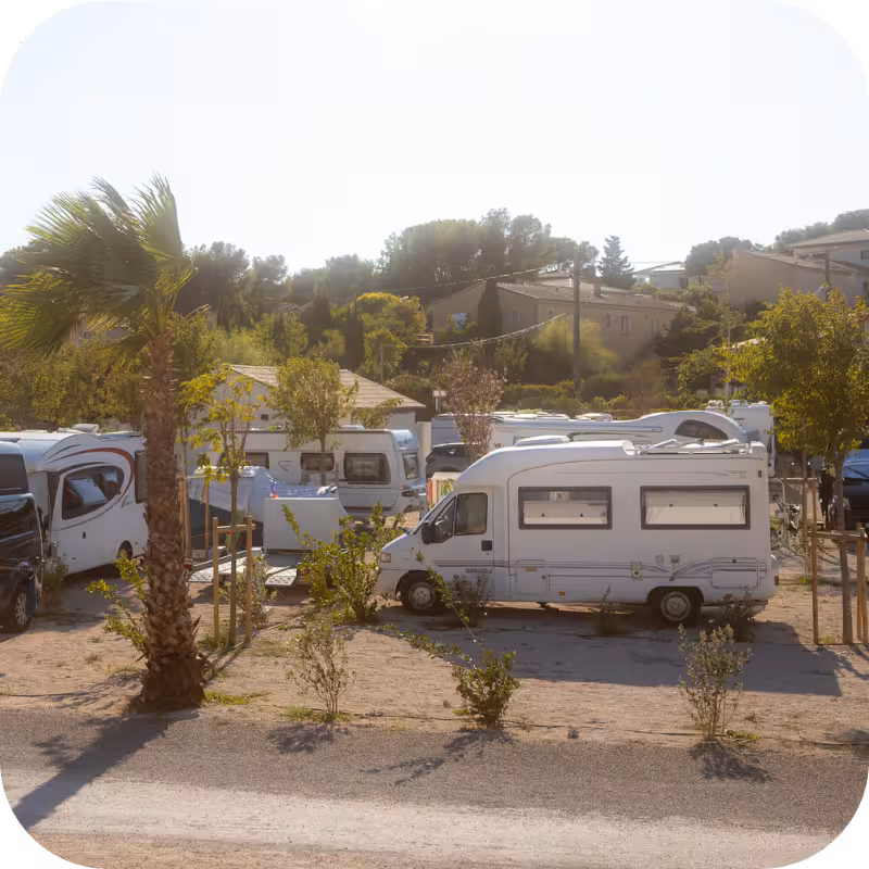 Petit camping car stationné sur emplacement au camping les Tamaris